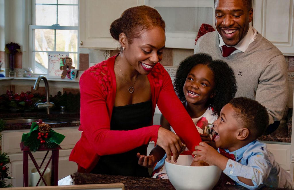 A Black family having fun in their kitchen while baking.